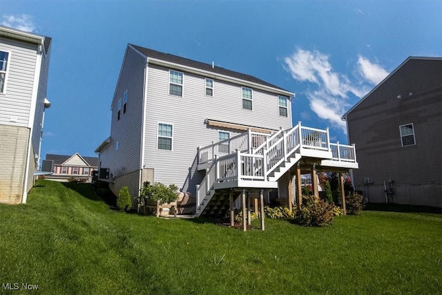 rear view of house featuring a yard and a wooden deck