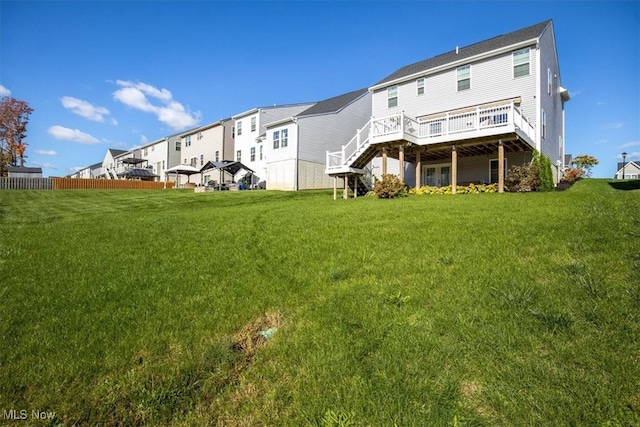 back of property featuring a deck and a lawn