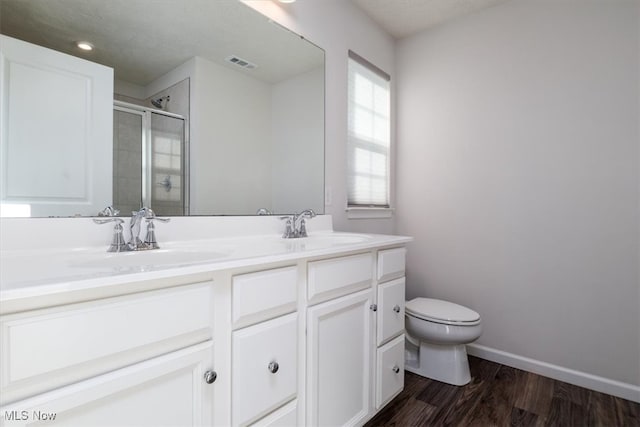 bathroom with vanity, toilet, hardwood / wood-style flooring, and a shower with shower door