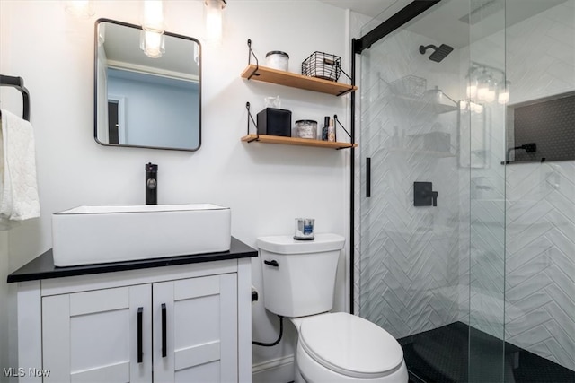 bathroom featuring vanity, a shower with shower door, and toilet