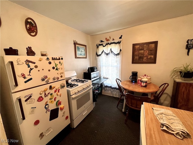 kitchen featuring dark carpet and white appliances