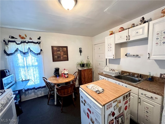 kitchen featuring white cabinetry, sink, butcher block countertops, and electric stove