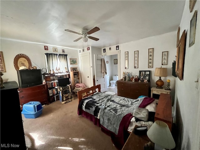 carpeted bedroom with ensuite bath and ceiling fan