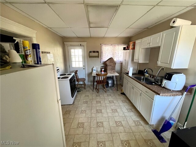 kitchen featuring white cabinetry, electric stove, a drop ceiling, and sink