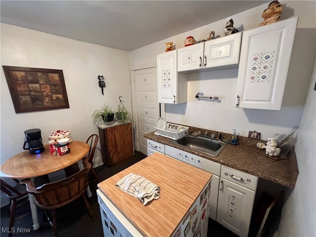 kitchen featuring white cabinetry, butcher block countertops, and sink