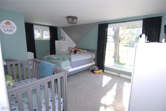 bedroom with a nursery area, white fridge, and carpet flooring