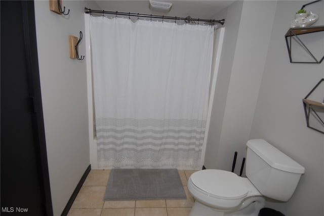 bathroom with tile patterned flooring, toilet, and curtained shower