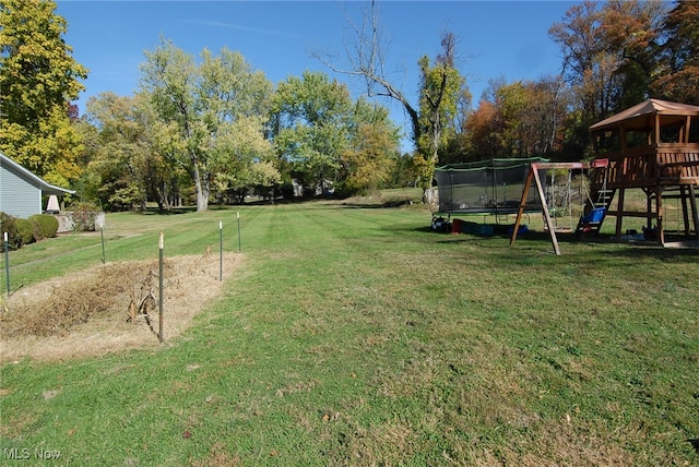 view of yard featuring a trampoline and a playground