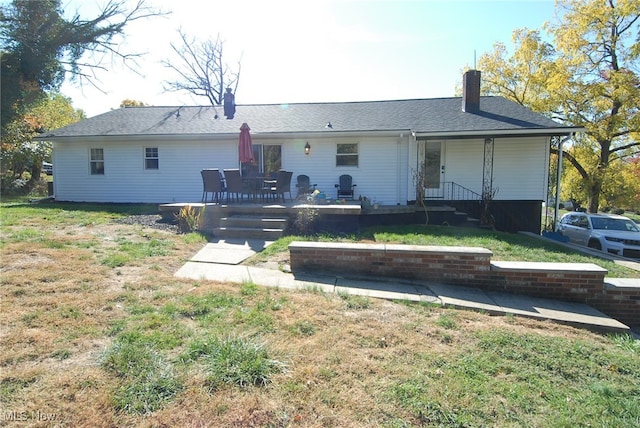 rear view of property featuring a lawn