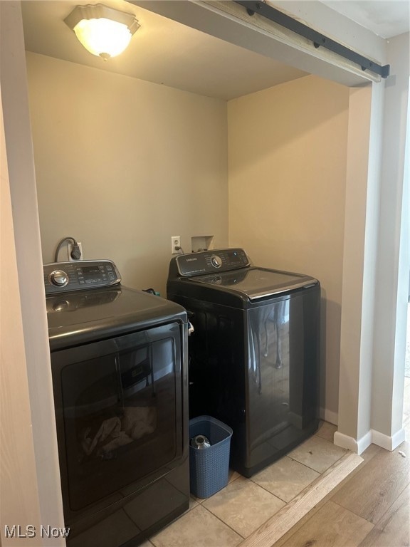 laundry room featuring washing machine and dryer and light wood-type flooring