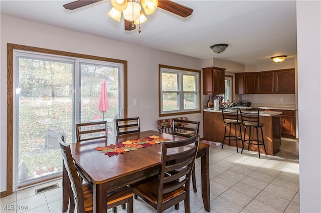 dining room featuring a healthy amount of sunlight, ceiling fan, and light tile patterned flooring