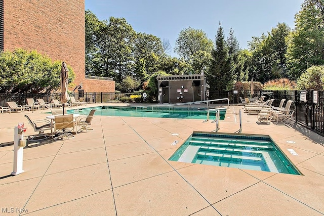 view of swimming pool featuring a patio and a hot tub