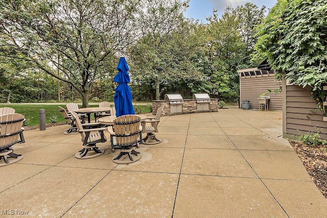 view of patio featuring a storage shed, a grill, and exterior kitchen