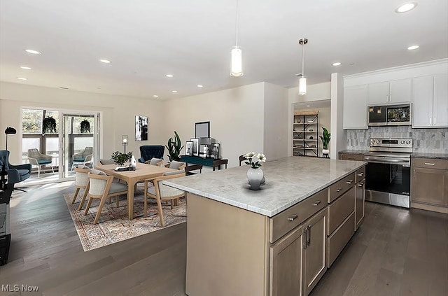 kitchen featuring hanging light fixtures, backsplash, dark hardwood / wood-style flooring, white cabinetry, and stainless steel appliances