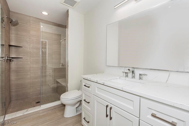 bathroom featuring toilet, an enclosed shower, vanity, and wood-type flooring