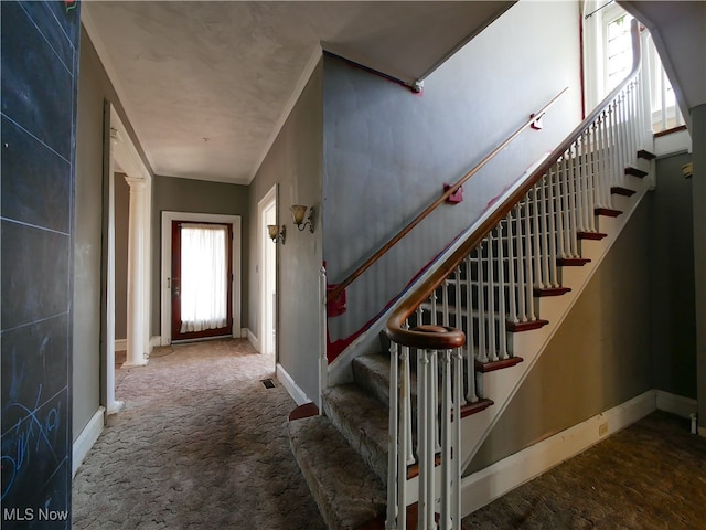 stairway featuring carpet flooring and decorative columns