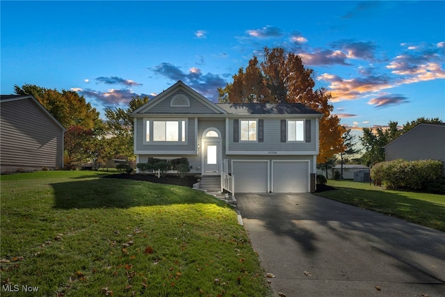 split foyer home featuring a yard and a garage