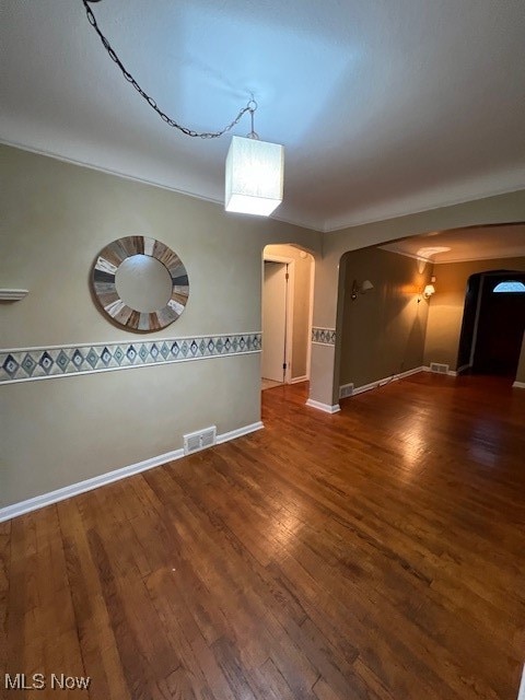 empty room with crown molding and dark hardwood / wood-style floors