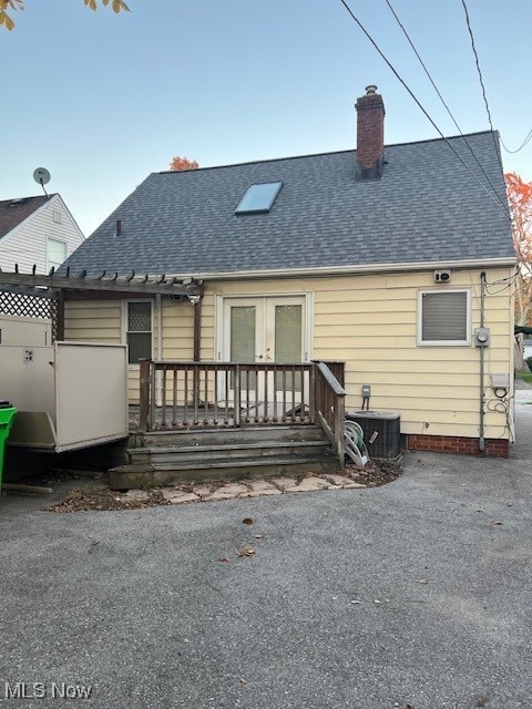 back of property with french doors and central AC