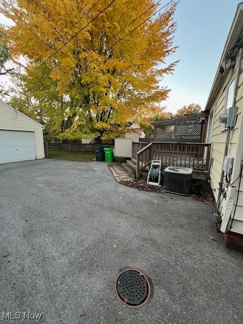 view of yard featuring cooling unit, an outbuilding, and a garage