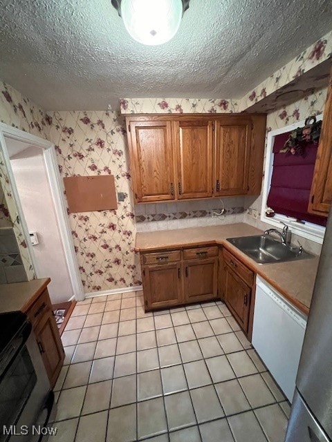 kitchen with light tile patterned flooring, sink, white dishwasher, a textured ceiling, and black electric range oven