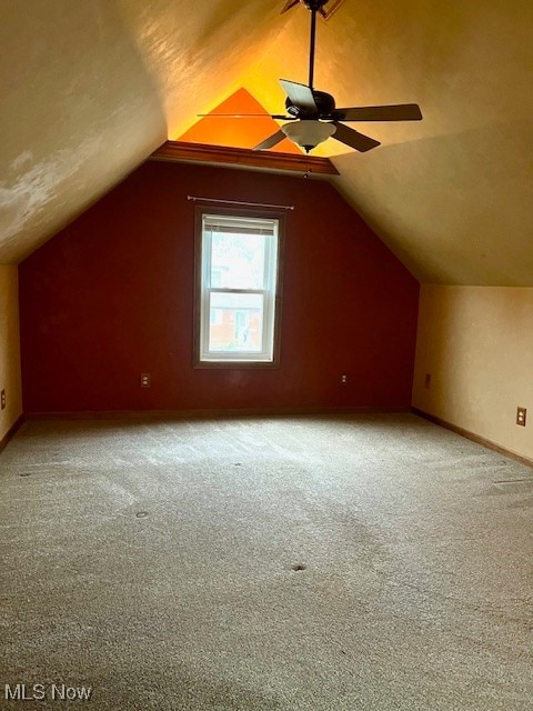 additional living space featuring lofted ceiling, carpet floors, and ceiling fan