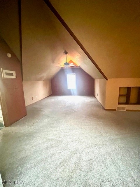 additional living space featuring ceiling fan, vaulted ceiling, and carpet floors