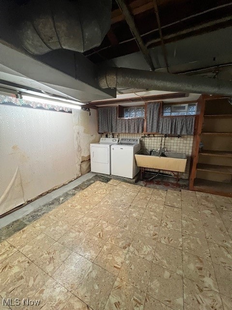 basement featuring independent washer and dryer and sink