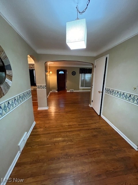 corridor featuring ornamental molding and dark hardwood / wood-style floors