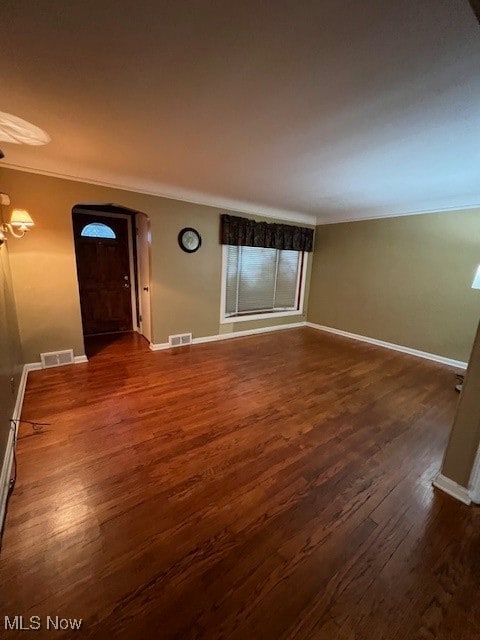 interior space featuring ornamental molding and dark hardwood / wood-style flooring