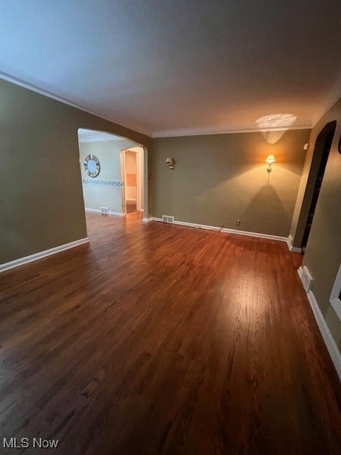 unfurnished room with crown molding and dark hardwood / wood-style flooring