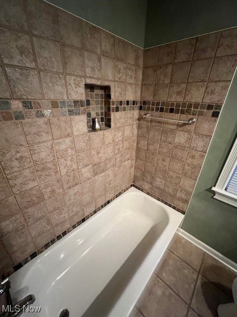 bathroom with tiled shower / bath and tile patterned floors