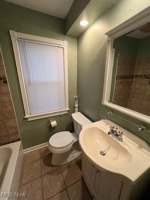 full bathroom featuring toilet, tiled shower / bath, vanity, and tile patterned flooring