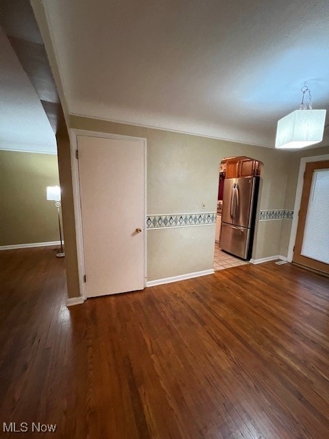 empty room with ornamental molding and wood-type flooring