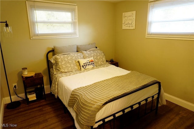 bedroom featuring multiple windows and dark hardwood / wood-style floors