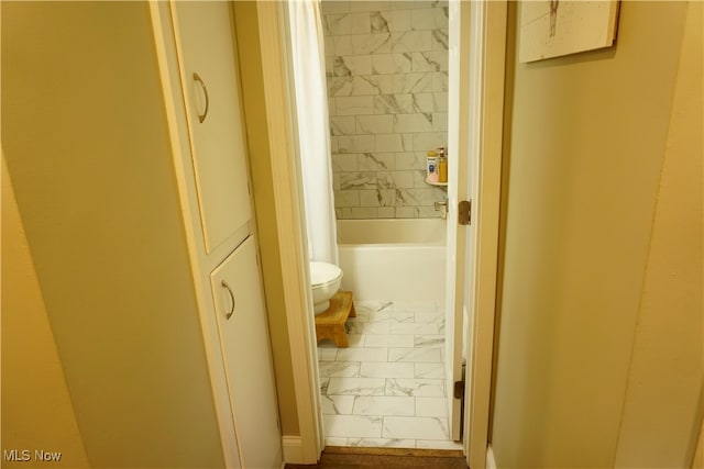 bathroom with toilet and tiled shower / bath combo