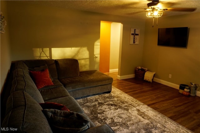 living room featuring ceiling fan, a textured ceiling, and hardwood / wood-style floors