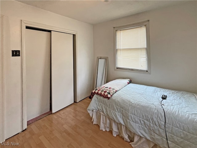 bedroom with light hardwood / wood-style flooring and a closet