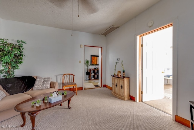 carpeted living room featuring a textured ceiling and ceiling fan