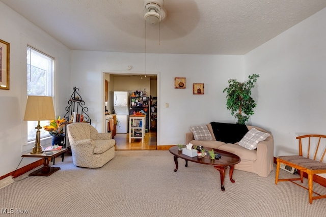 living room featuring a textured ceiling, carpet, and ceiling fan