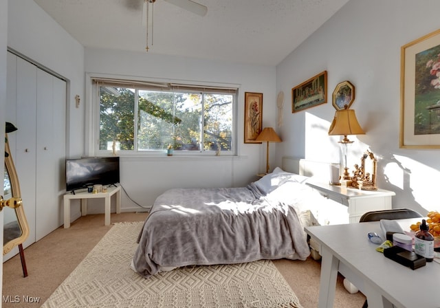 bedroom with light carpet, a closet, and ceiling fan