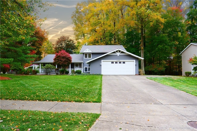 view of front of home with a yard, a garage, and covered porch