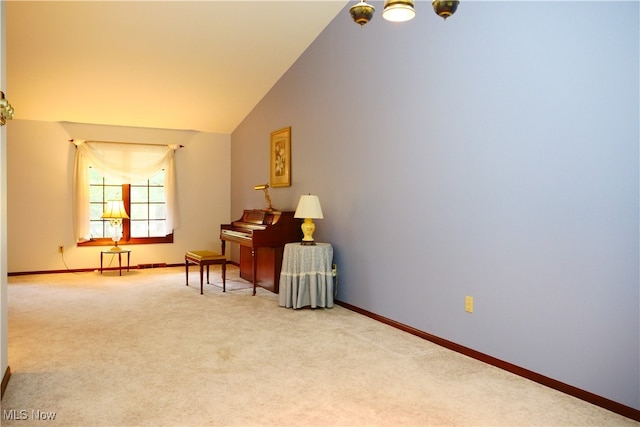 sitting room with lofted ceiling and light colored carpet