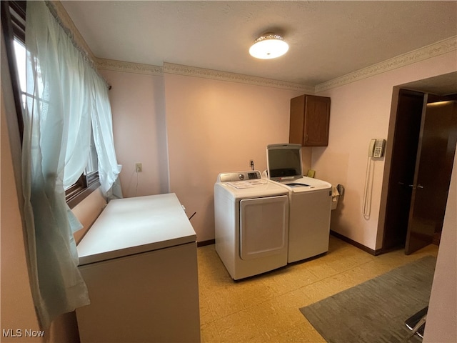 laundry room featuring cabinets, washer and dryer, and a textured ceiling