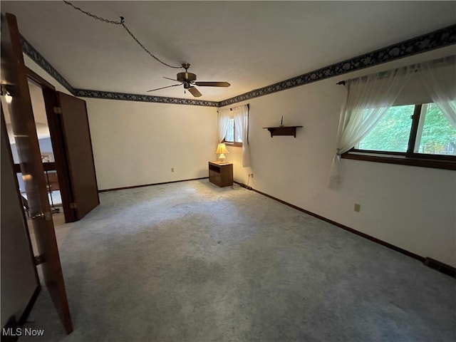 carpeted spare room with ceiling fan