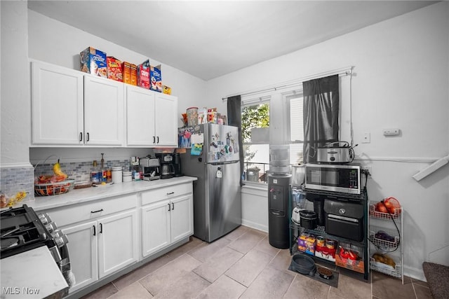 1633 Hopkins Ave, Lakewood, OH 44107 - kitchen featuring appliances with stainless steel finishes, white cabinets, light countertops, and backsplash