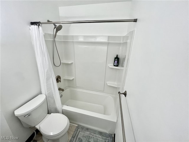 bathroom featuring shower / bath combination with curtain and toilet