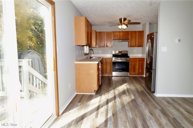 kitchen featuring sink, dark wood-type flooring, appliances with stainless steel finishes, and a textured ceiling