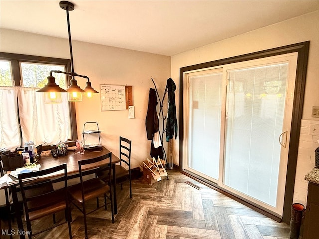 dining area with dark parquet flooring