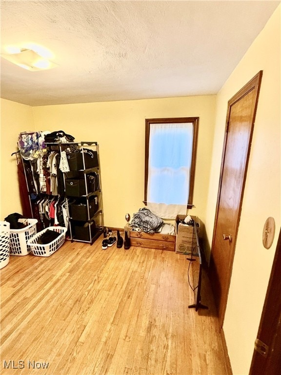 misc room with a textured ceiling and wood-type flooring